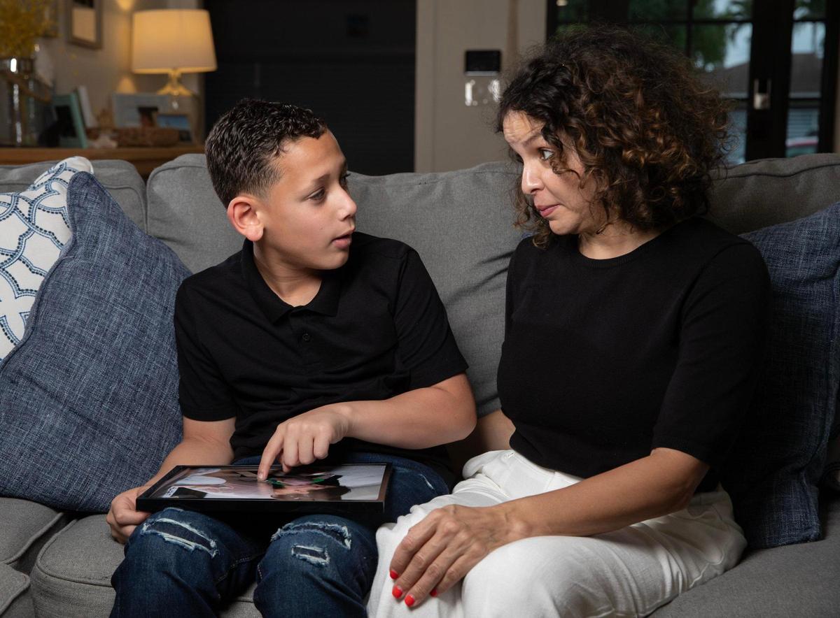 Sebastian de la Cruz, now 10, and his aunt Pamela Rauseo look back on the day 10 years ago when Sebastian stopped breathing on the highway. Rauseo stopped in traffic and performed CPR on the baby. They gathered at Rauseo’s home on Monday, Feb. 12, 2024.