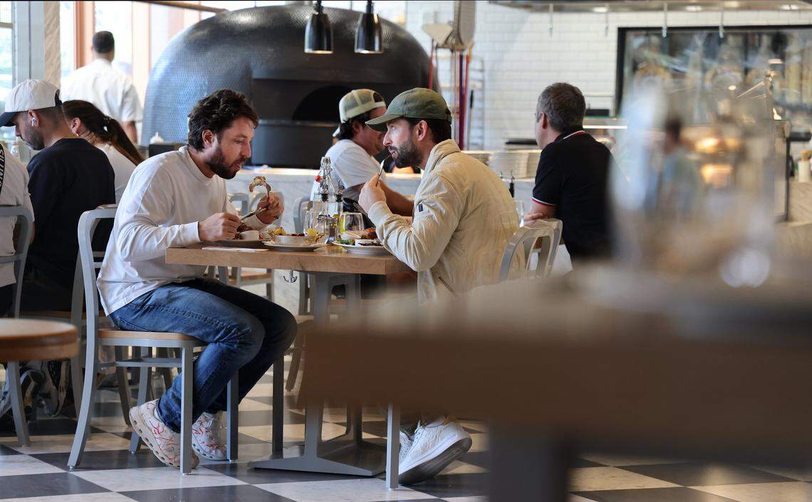 A patrons enjoy lunch at the new Casa Tua Cucina in Miami's Wynwood Art District on Thursday, April 16, 2026. Casa Tua Cucina in Wynwood, a spacious, upscale Italian food hall and restaurant features an open layout with high ceilings, communal tables, and multiple dedicated dining areas-making it suitable for both intimate dinners and larger group gatherings.