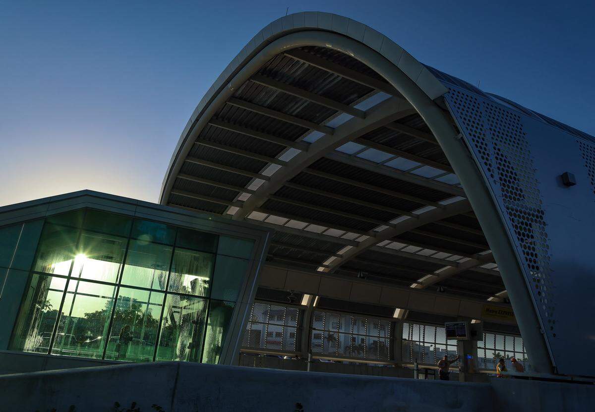 An unidentified commuters, left, enjoys the cool waiting area of the Coral Reef Drive station on the first day of Miami-Dade's $300 million rapid-transit bus line known as “Metro Express” on Monday, October 27, 2025, just west of Richmond Heights on Coral Reef Drive and U.S. 1.  Many first day riders complained about crowded buses and long travel times due to red lights on the express lane.