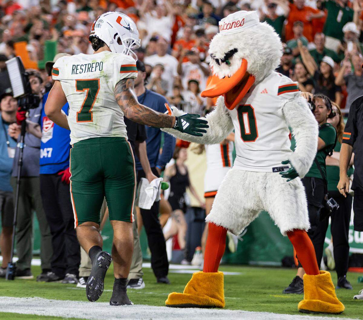 Miami Hurricanes wide receiver Xavier Restrepo (7) celebrates with Sebastian the Ibis after scoring a touchdown against the South Florida Bulls in the second half of their NCAA college football game at the Raymond James Stadium on Saturday, Sept. 21, 2024, in Tampa, Fla.