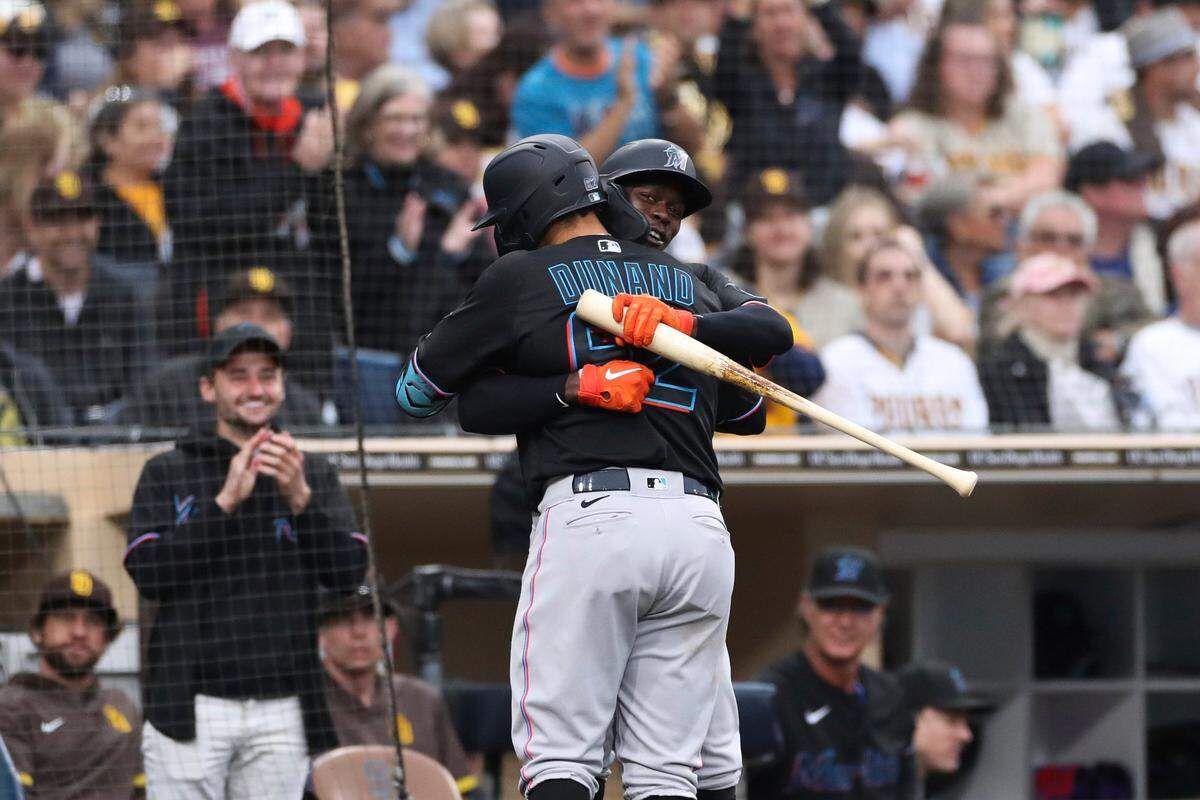 Miami Marlins’ Joe Dunand, foreground, is congratulated by Jazz Chisholm Jr. after hitting a solo home against the San Diego Padres in the third inning of a baseball game Saturday, May 7, 2022, in San Diego. The home run was Dunand’s first career hit.