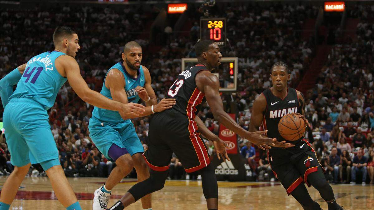 Bam Adebayo, del Heat, le deja el balón a Josh Richardson y bloquea a los jugadores de los Hornets Nicolas Batum (5) y Willy Hernangómez (41), el 20 de octubre en el American Airlines Arena.