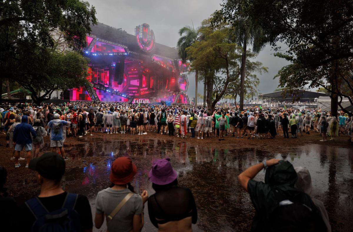 Attendees avoid a huge water puddle after a rainstorm during the third day of Ultra Music Festival on Sunday, March 30, 2025, at Bayfront Park in downtown Miami, Fla. The festival closed its doors for about a half hour urging fans to take cover from the lightning and rain, but then opened back up after it passed. 