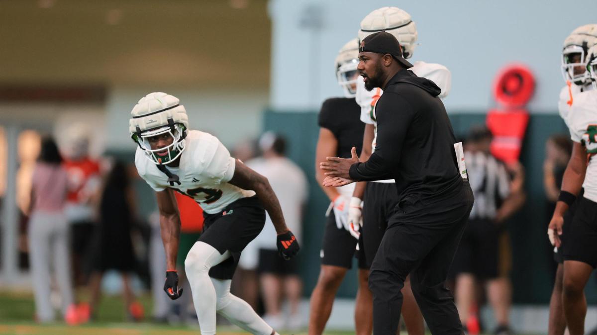 Miami Hurricanes defensive backs coach Zac Etheridge works with defensive back Emmanuel Karnley (13) during spring practice at the Carol Soffer Indoor Practice Facility at the University of Miami in Coral Gables, Florida, Tuesday, April 1, 2025.
