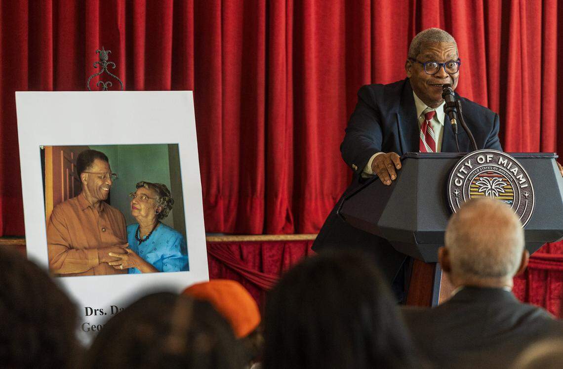 George Simpson Jr. speaks next to a picture of his parents during the street renaming ceremony to honor them, Florida's first board certified Black pediatrician, Dazelle Simpson and her husband the state's first Black surgeon, George Simpson, celebrated at the Christ Episcopal Church, in Coconut Grove, on Friday, January 23, 2026.