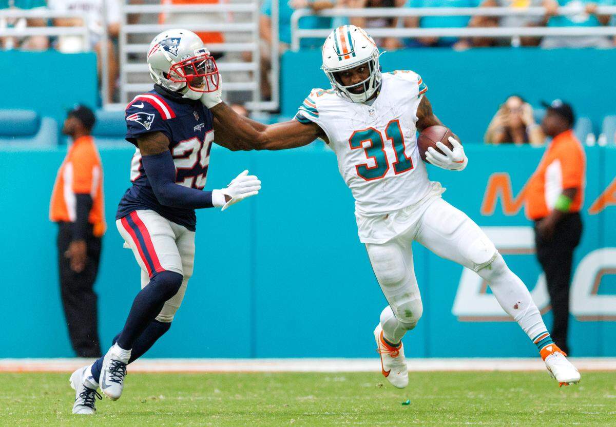 Miami Dolphins running back Raheem Mostert (31) runs as New England Patriots cornerback J.C. Jackson (29) defends during fourth quarter of an NFL football game at Hard Rock Stadium on Sunday, Oct. 29, 2023 in Miami Gardens, Fl.