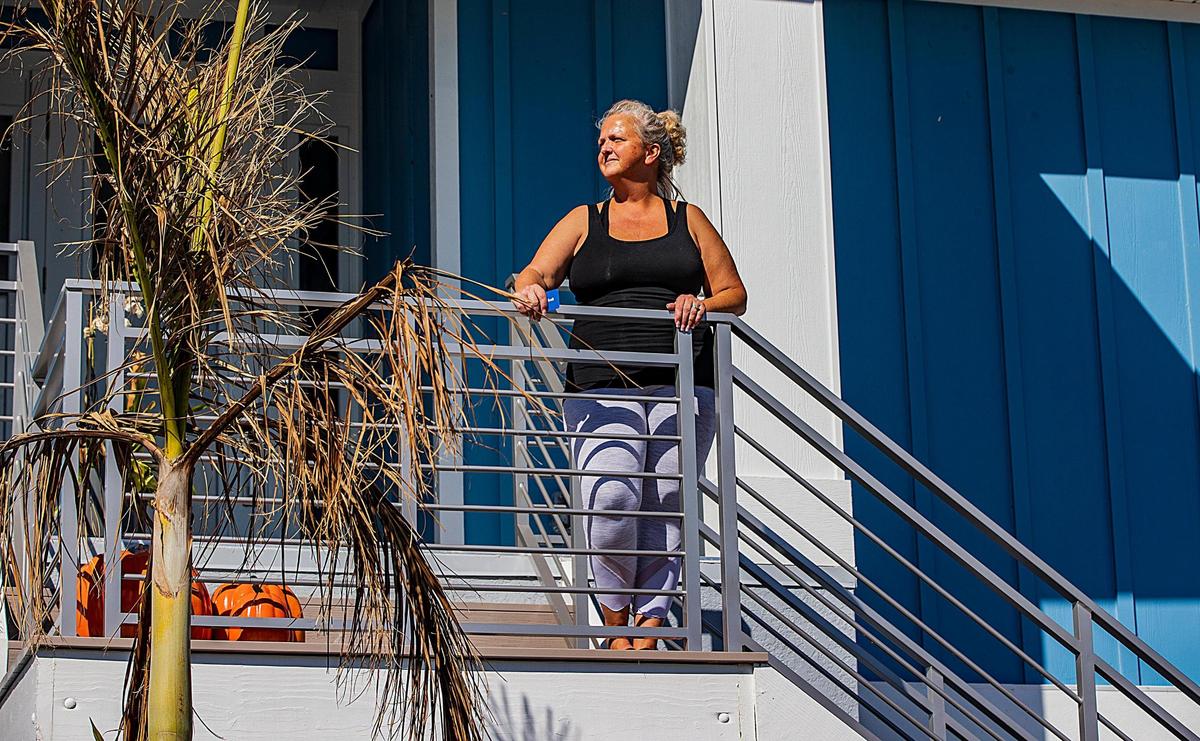 Amy Rizzo stands by the entrance of her Lagoon Road stilted house Wednesday, Oct. 26, 2022. She and her husband stayed in the house when Hurricane Ian made landfall in the area Wednesday, Sept. 28, 2022.