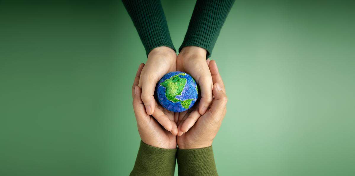 pair of small and big hands hold earth ball
