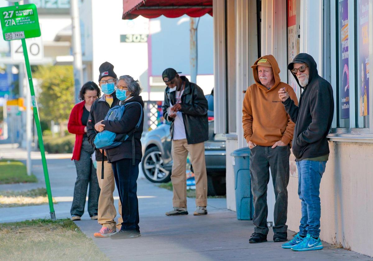 Several bundled people gather as they wait for the city bus along Northwest 27th Ave. in Miami on a chilly 50s Wednesday morning, Jan. 8, 2025.