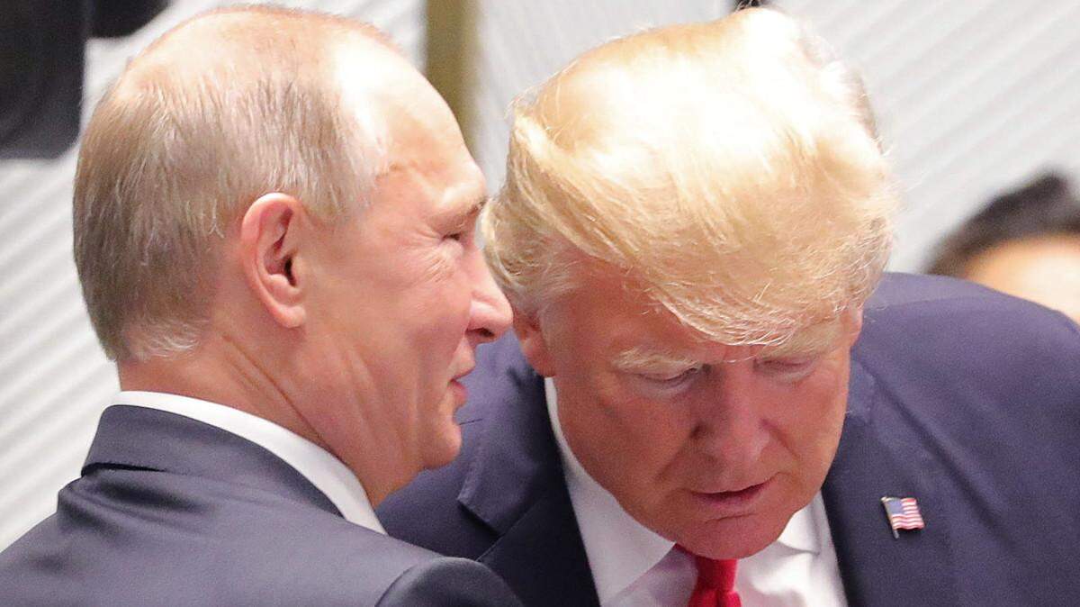 Russian President Vladimir Putin whispers to President Trump at a meeting of world leaders at the 25th Asia-Pacific Economic Cooperation Summit in 2018.