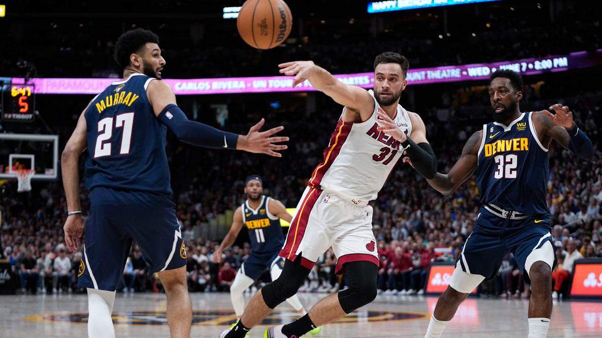 Miami Heat guard Max Strus (31) passes the ball between Denver Nuggets guard Jamal Murray and forward Jeff Green during the first half of Game 2 of basketball’s NBA Finals, Sunday, June 4, 2023, in Denver.