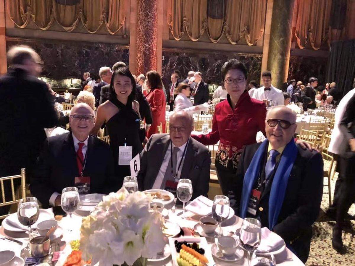 Xianqin Qu poses with top Republican donors at a fundraiser for President Donald Trump held at a restaurant in New York City, Dec. 2, 2017.