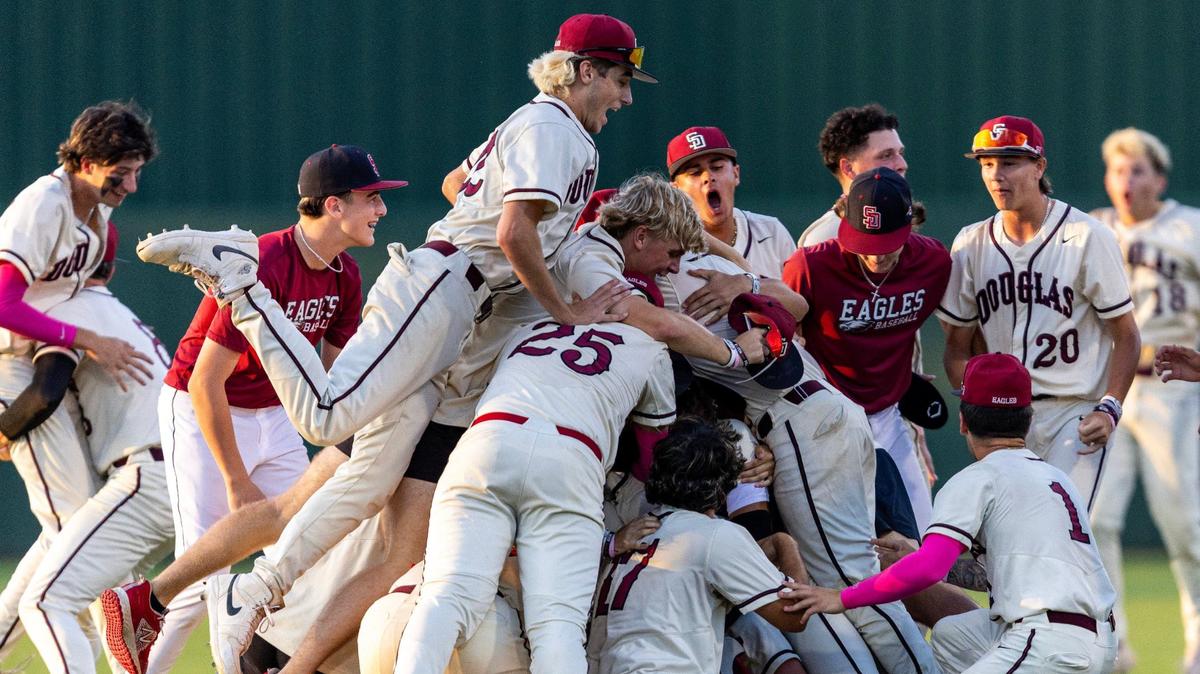 Marjory Stoneman Douglas players dog pile on Nick Diaz (11) after he hit a walk-off single to defeat Windermere 3-2 in extra innings for the Class 7A state baseball championship game at Hammond Stadium on Saturday, May 18, 2024, in Fort Myers, Fla.