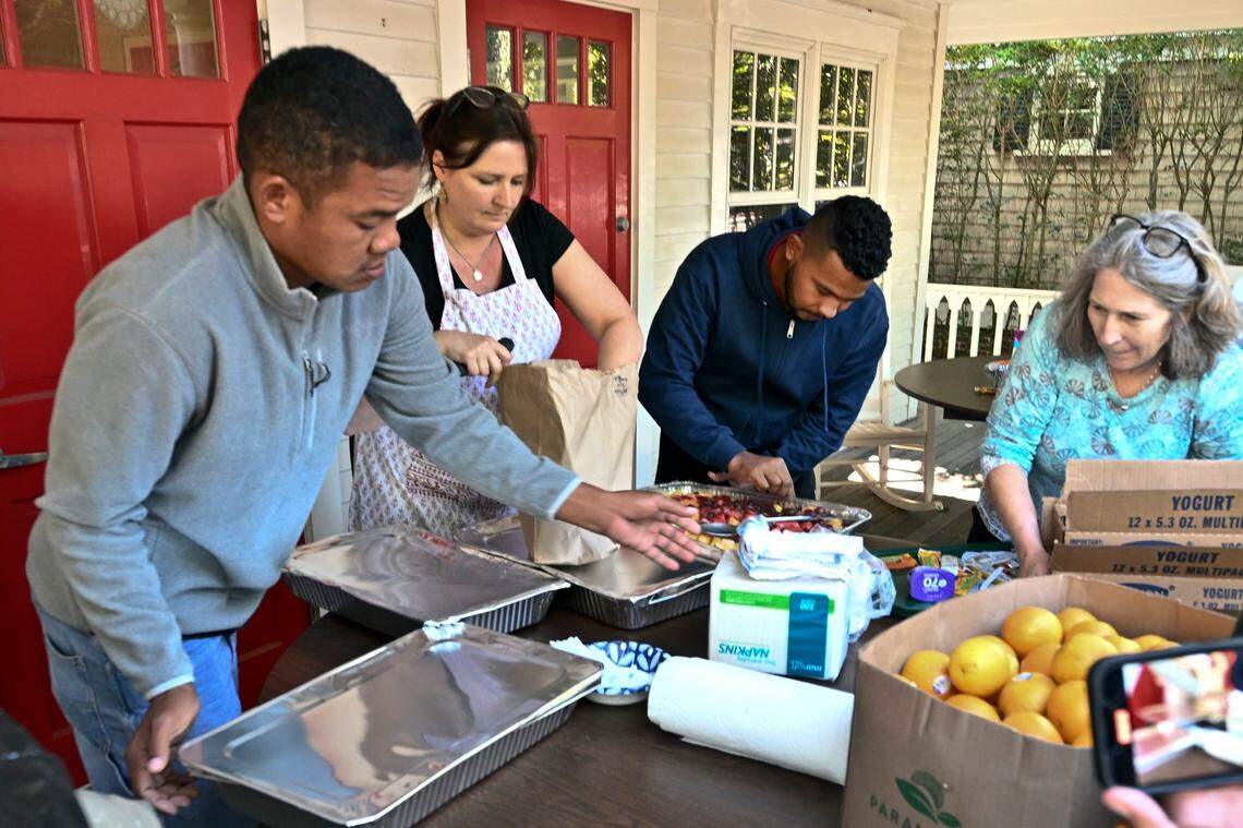 Volunteers prepare food for immigrants outside St. Andrews Episcopal Church on Thursday, Sept. 15, 2022, in Edgartown, Massachusetts, on Martha’s Vineyard.