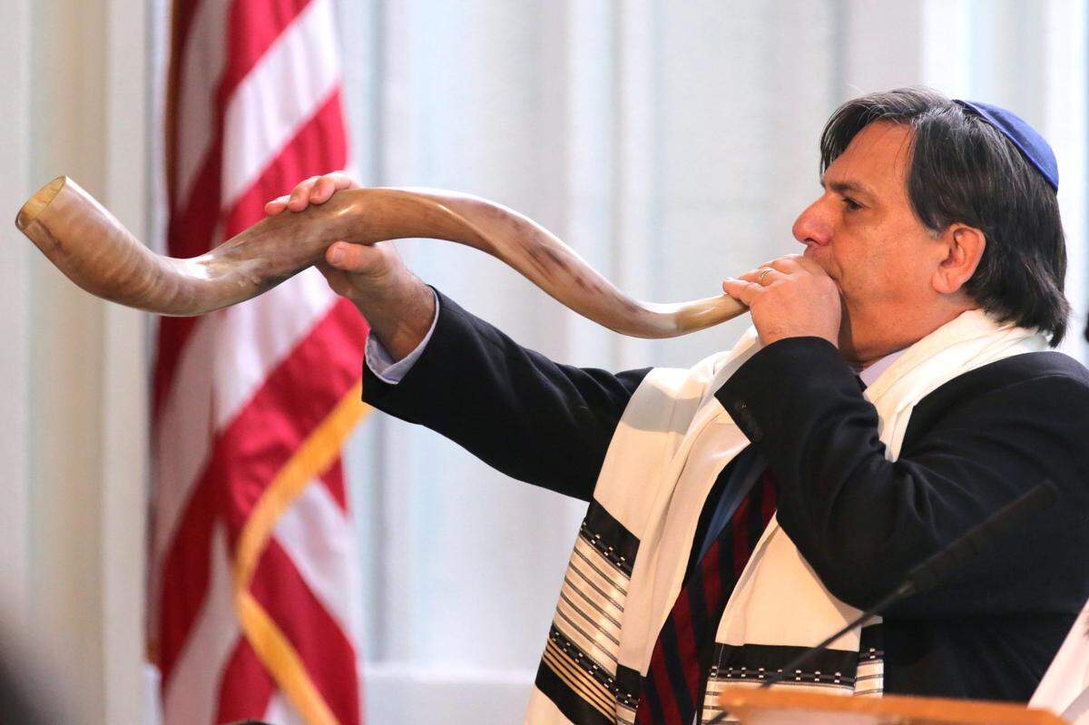 Dr. Edward Gross blows a shofar during a ceremony to signal the start of Rosh Hashana and the High Holy Days at Temple Judea in Coral Gables, Florida, on Sept. 30, 2019.