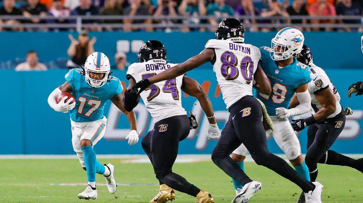 Miami Dolphins wide receiver Jaylen Waddle (17) runs with ball against Baltimore Ravens outside linebacker Tyus Bowser (54) during the second quarter of an NFL football game at Hard Rock Stadium on Thursday, November 11, 2021 in Miami Gardens, Florida.