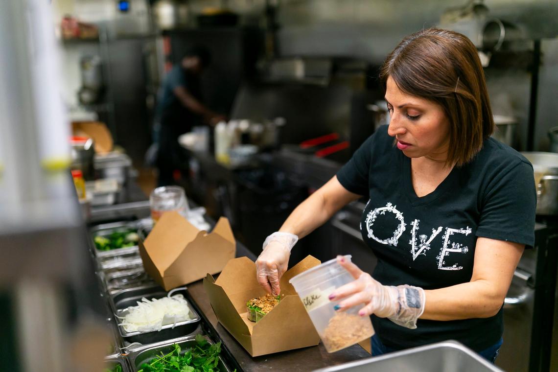 Ana Lugo, 43, who usually is a waiter, helps prepare orders as a food runner at the Vietnamese-Cajun restaurant Phuc Yea in Miami’s Upper East Side.