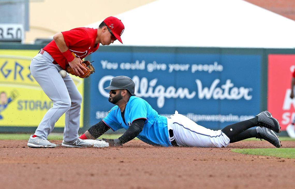 Miami Marlins Jonathan Villar (2) slides into second base as St Louis Cardinals Tommy Edman (19) fumbles the ball in the first inning at Roger Dean Chevrolet Stadium in Jupiter, Florida, February 24, 2020.