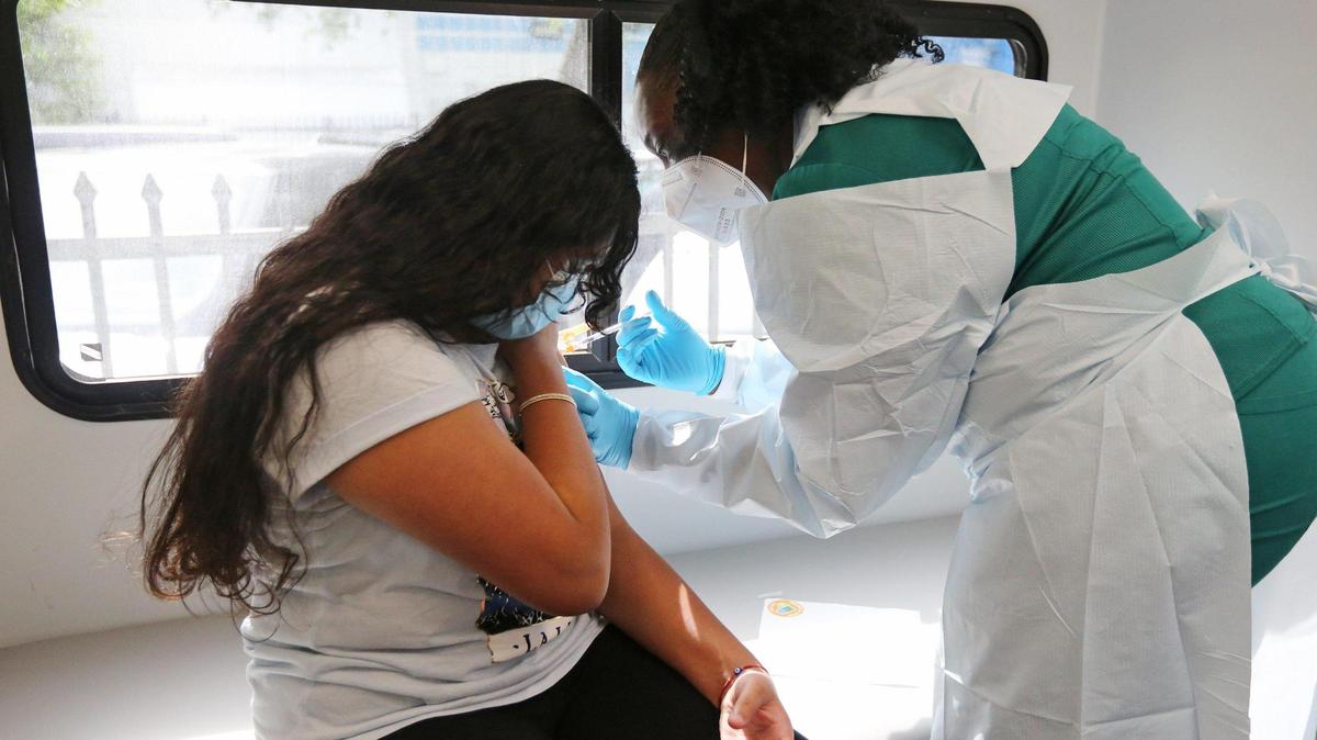 Jenna Ramkhelawan, 12, receives her first dose of the Pfizer vaccine from UM Health LPN Delores Fye as part of the UHealth pediatric mobile unit’s effort to provide free COVID-19 vaccines to uninsured and underprivileged children and parents at the Center for Haitian Studies in Little Haiti on Tuesday, May 18, 2021.