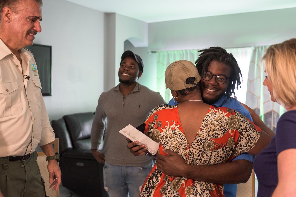 Herby Zephir hugs his mom, Rose Francois, after Zoo Miami’s Ron Magill presented him with the Ron Magill Conservation Endowment scholarship in Homestead on Dec. 20, 2019. The $10,000 award, funded by Magill’s endowment fund and Zoo Miami Foundation, will help Zephir support his studies at UF and potentially help him go to law school.