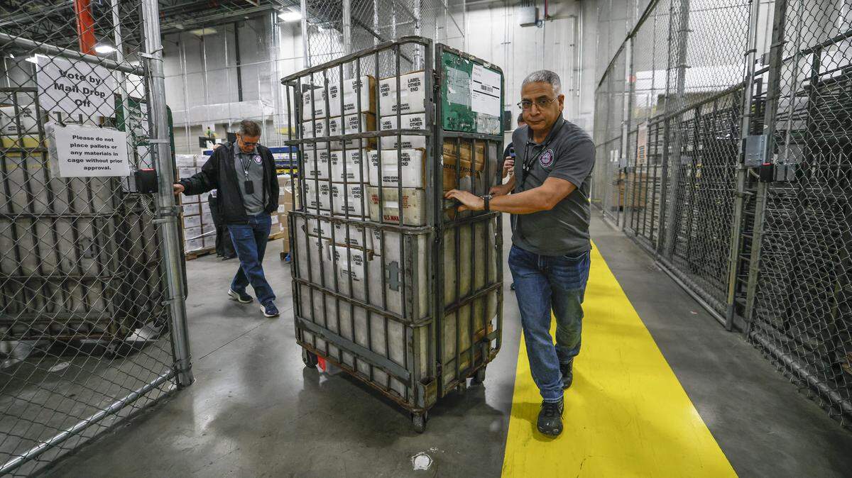 Engelbert Asiatico and fellow employees prepare to load carts full of mail ballots onto a waiting USPS truck in the loading bay at the Miami-Dade's Supervisor of Elections Office in Doral, Florida, on Thursday, March 19, 2026. The ballots will be delivered to voters for the upcoming city of Coral Gables election.