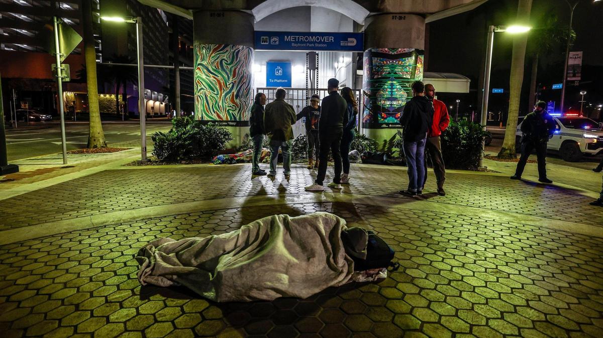 A person sleeps under the Metromover’s Bayfront Park Station as Ron Book, the chair of the Miami-Dade Homeless Trust, joins others during the Homeless Trust’s biannual homeless census in Miami on Thursday, Jan. 23, 2025.