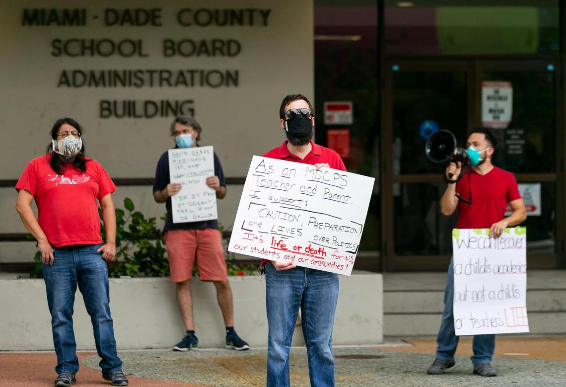 From left, teachers Charles Pilamunga, Jeff Raymond, Thomas Fiori, and Richard Ocampo participate in a rally at Miami-Dade County School Board headquarters Monday. The rally, which was led by Rank and File Educators of Miami-Dade, a faction of the United Teachers of Dade, opposed state officials pressuring school administrators to open in-person classes on Monday.