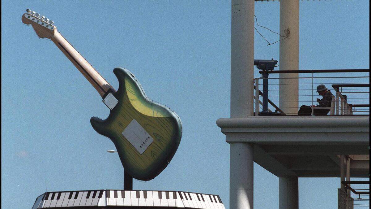 A solitary man eats lunch with a view of the Hard Rock Cafe rooftop guitar in 1998. The guitar is a replica of a 1957 Fender Stratocaster built 22 times bigger than its normal size.