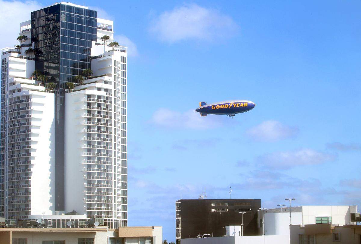 A view of the Good Year blimp flying near one of the towers of Trump on the beach in Sunny Isles Beach on a beautiful day on Thursday, February 7, 2013.