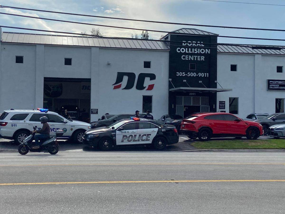 Police and federal agents gather in front of Doral Collision Friday, Aug. 16, 2024. Sources say the raid is in connection with the Aug. 27, 2019, plot to kill Alex Vega, a famed Miami car designer to the stars.