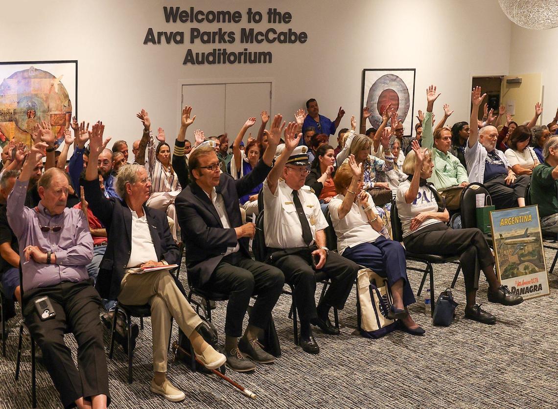 Attendees at a Miami-Dade County historic preservation board meeting raise their hands to indicate support for the designation of a 1929 Pan American Airways hangar at Miami International Airport, the last standing building from the city’s original airport, as a historic landmark. The hearing took place at the Miami-Dade Main Library downtown.
