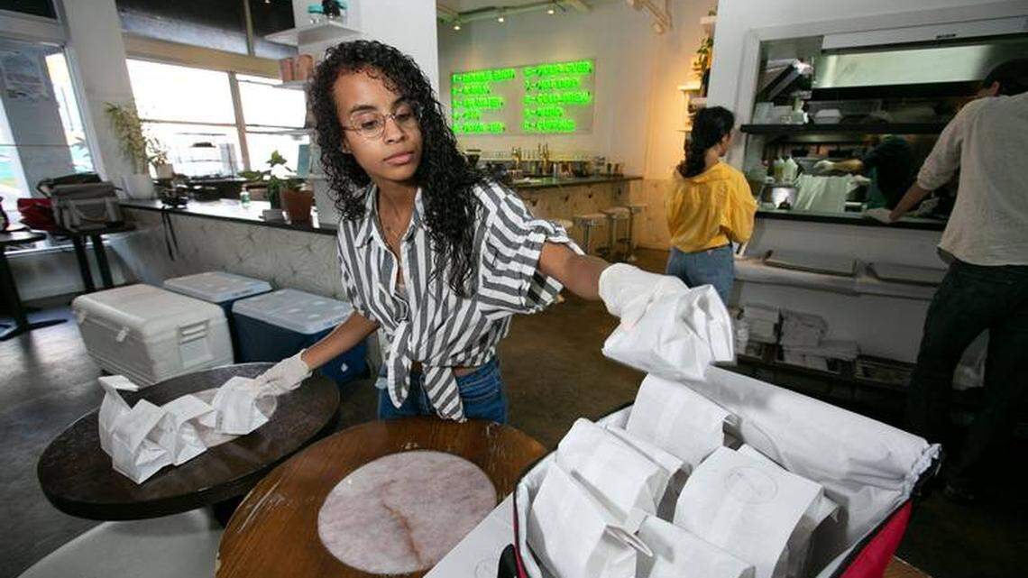 Small businesses in Miami stand to benefit from the American Rescue Plan. Here, in 2020, Virginia Vasquez prepares a food delivery at All Day, a coffee shop and restaurant in downtown Miami.