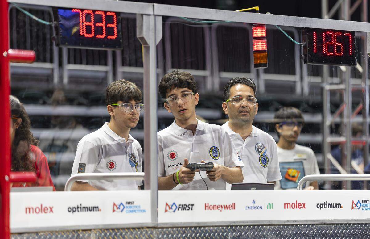 Ismail Eruz, 15, left, and Burak Pektas, 17, both members of MASAL, a team from Marmaris Sabanci High School in Muğla, Turkey, drive their robot, Fairy Tale, as their coach, Ismail Pektas, gives instructions during the 2026 FIRST Robotics South Florida Regional Competition at the University of Miami’s Watsco Center on Friday, April 10, 2026, in Coral Gables, Fla. Participants from local school districts, surrounding states, and international teams are competing for an opportunity to earn a spot at the 2026 FIRST World Championship.