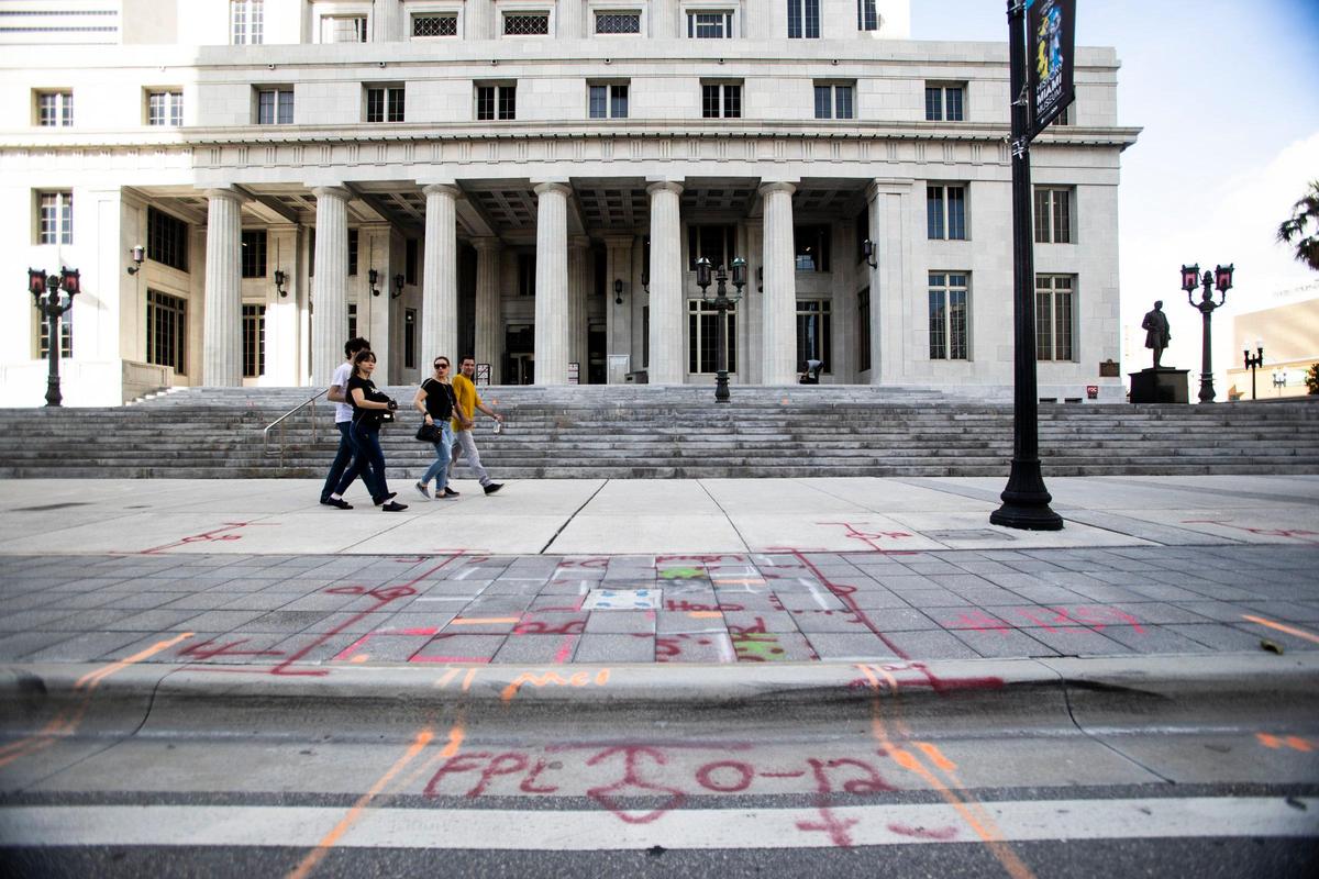 Markings for underground utilities have been painted all over the sidewalk in front of downtown Miami’s county courthouse. The paint is supposed to fade away but it doesn’t.