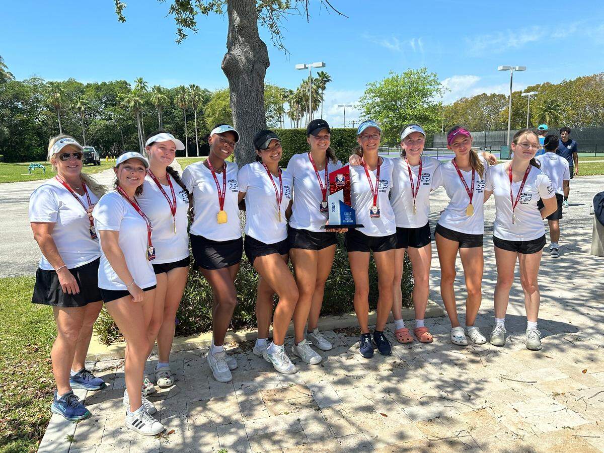 Palmetto’s girls’ tennis players and coach Kelly Gibson (left) celebrate after repeating as GMAC champions on Tuesday at Crandon Park in Key Biscayne, Fla.
