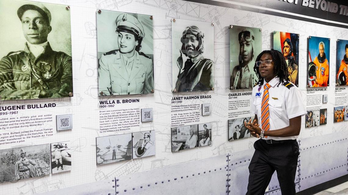 Student pilot Paladre Johnson, 19, walks past an exhibit showcasing pioneering Black aviators during the unveiling of a new aviation museum at FMU’s William Lehman Aviation Center in Miami Gardens.