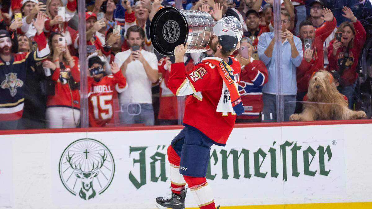Florida Panthers center Aleksander Barkov (16) kisses the Stanley Cup after defeating the Edmonton Oilers in Game 7 of the Stanley Cup Final at Amerant Bank Arena on Monday, June 24, 2024, in Sunrise, Fla. Brodie is seated at far right.