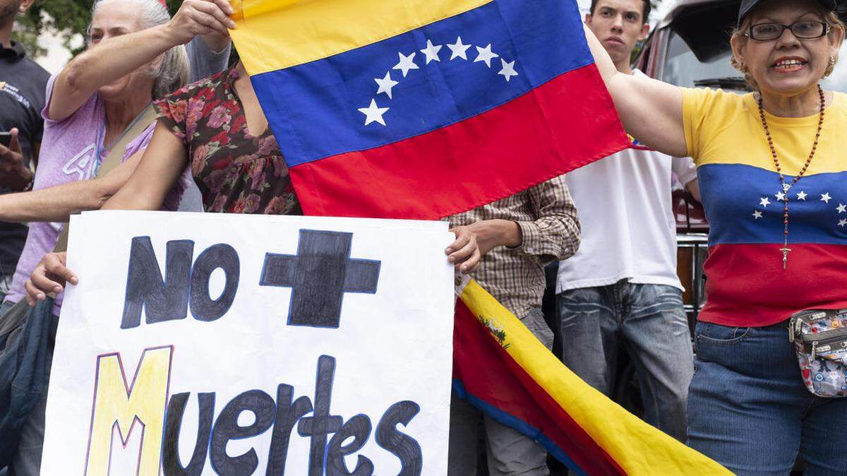 Angry Venezuelans protest the extrajudicial deaths of opposition activists under the Maduro regime.