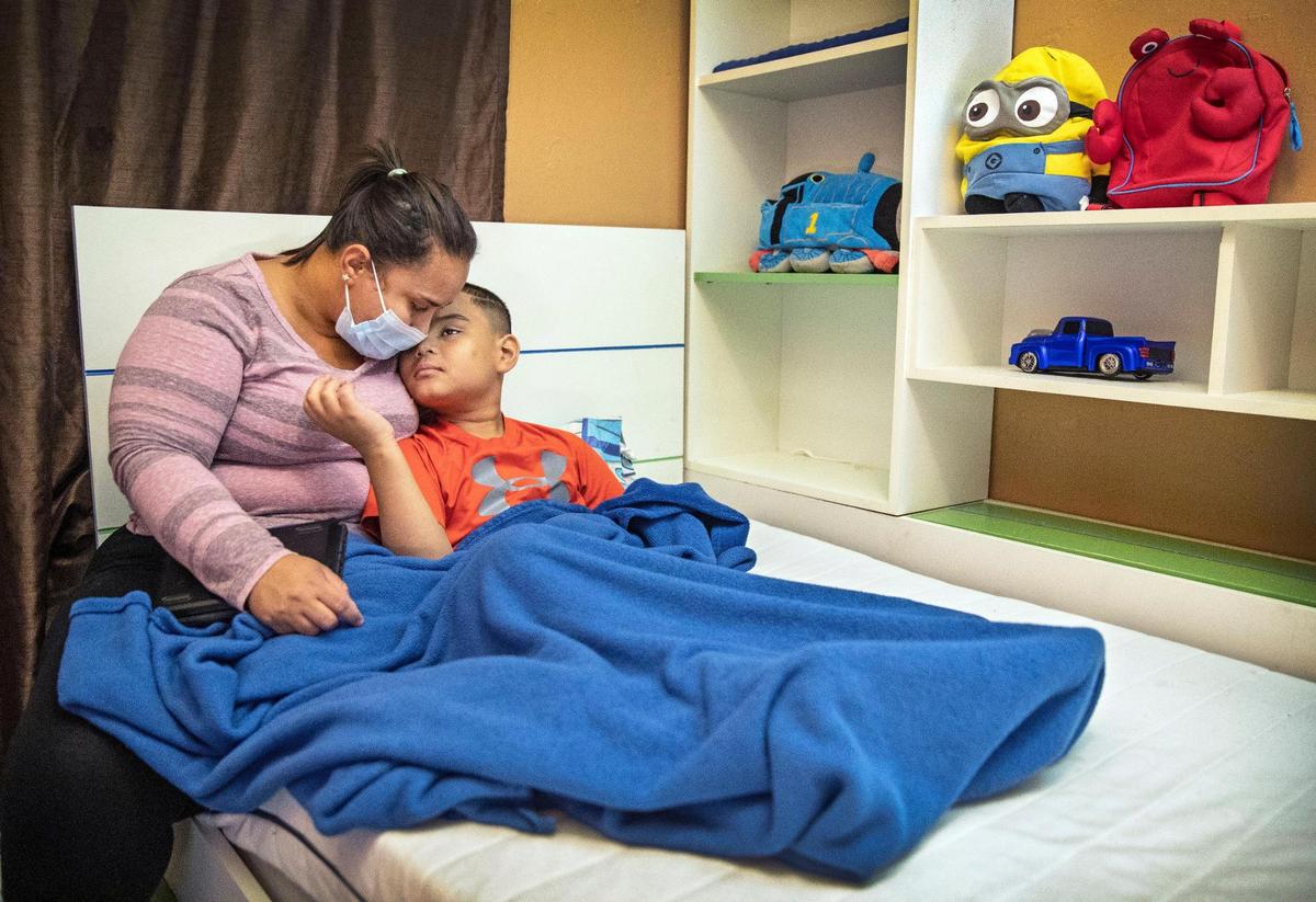 Maria Madrid comforts her son Joshua Cruz, 9, who has severe non-verbal autism, impulsive behaviors and epilepsy.