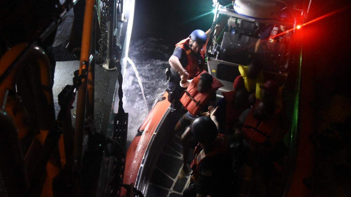 Members of the Coast Guard Cutter Robert Yered (WPC-1104) help migrants transfer from the cutter’s small boat to the cutter after the crew interdicted 11 migrants and two suspected smugglers Sunday, Dec. 9, 2018 approximately 12 miles east of Miami.