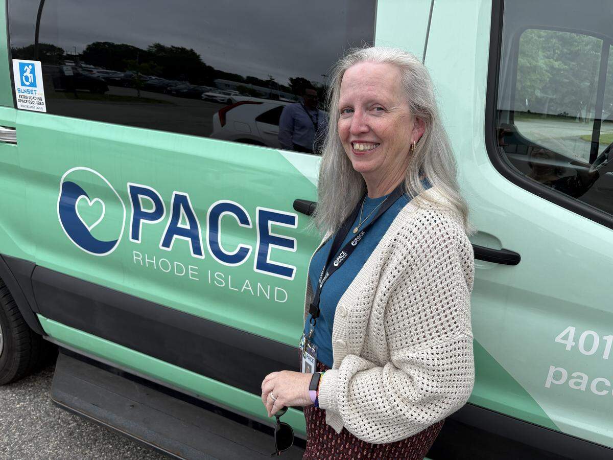 Kriss Auger, gerente de trabajo social y salud conductual de la Organización PACE de Rhode Island, afuera de la camioneta utilizada para transportar a los participantes al centro PACE en East Providence.