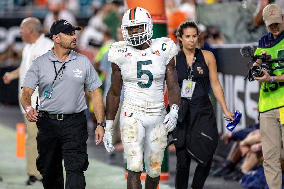 Miami Hurricanes safety Amari Carter (5) is escorted off the field after being disqualified for targetting in the third quarter of a football game versus Virginia at Hard Rock Stadium in Miami Gardens on Friday, October 11, 2019.