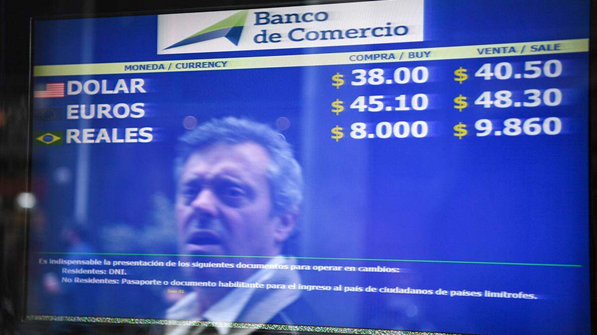A passerby is reflected in the buy-sell board of a bureau de exchange in Buenos Aires in September 2018, after the government took an $57 billion crisis loan from the International Monetary Fund.