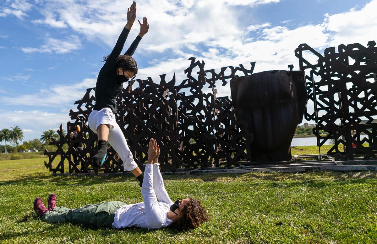 Eva Martinez, 20, and Kael Baez, 20, perform a contemporary dance during the opening ceremony of an outdoor art exhibition by renowned Spanish artist Manolo Valdes at Doral Central Park in Doral, Florida on Saturday, December 5, 2020. At least 16 sculptures by Valdes are being installed across Doral in hopes of attracting an art scene to the city.