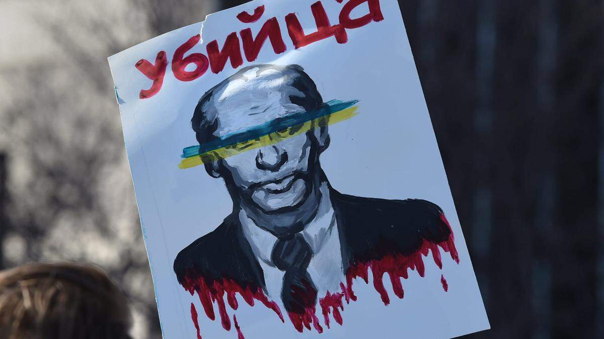 A person holds a sign condemning Russian President Vladimir Putin at the “Stand with Ukraine” solidarity event in downtown Reno in 2022.