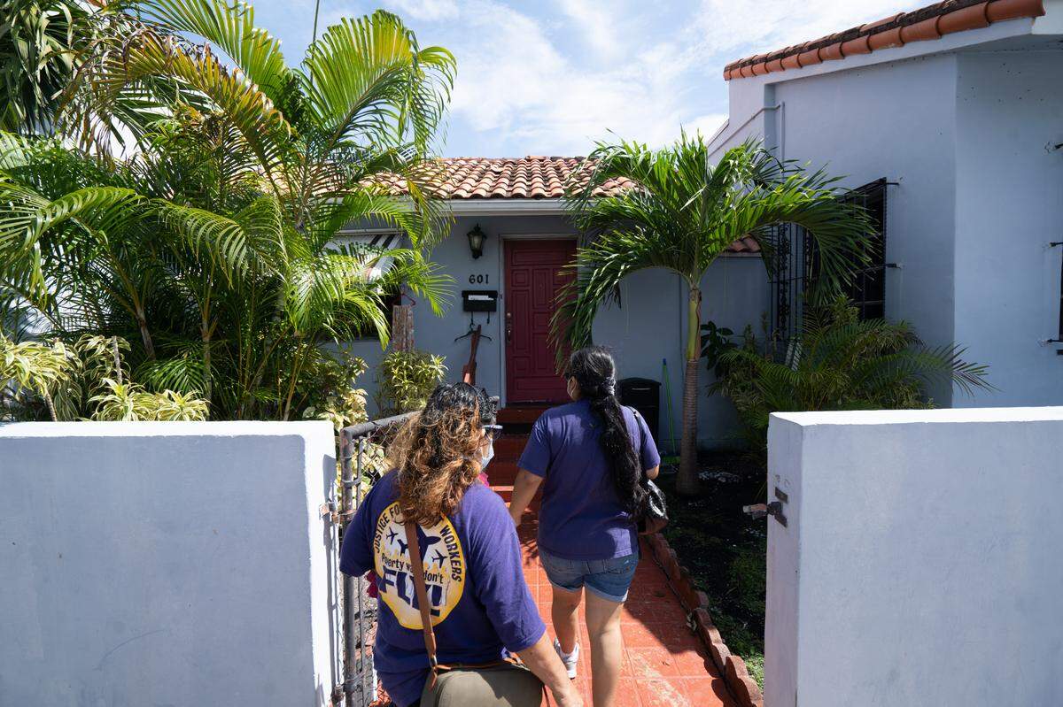 Elizabeth Valderrama and Alejandra Poccori, members of 32BJ SEIU, knock on doors in Little Havana on October 10, 2020.
