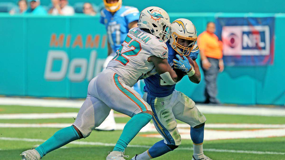 Miami Dolphins linebacker Raekwon McMillan (52) pushes back Los Angeles Chargers running back Austin Ekeler (30) during third quarter of an NFL football game against Los Angeles Chargers at Hard Rock Stadium on Sunday, September 29 2019, in Miami Gardens.