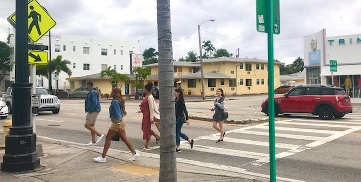 Pedestrians cross Biscayne Boulevard at NE 72nd Street, counting on cars to stop for the yellow-flashing beacon on the side of the street at the mid-block crosswalk. The beacon in the median was knocked down a year ago and hasn’t been replaced.