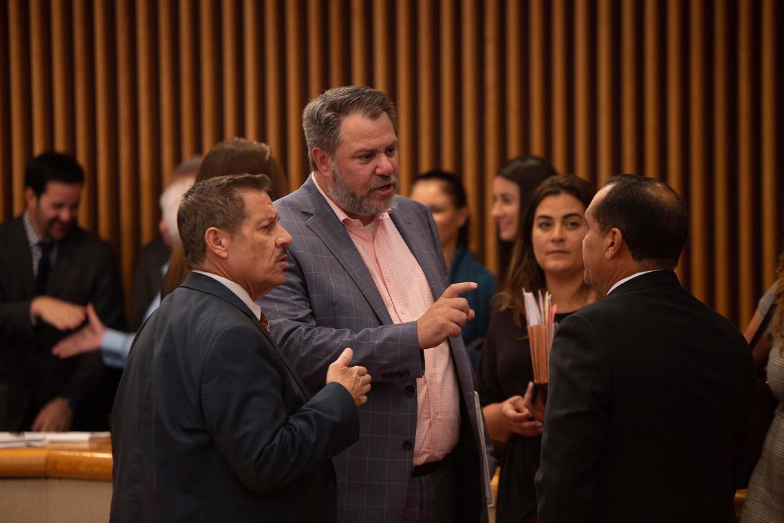 Miami-Dade Commissioner Jose “Pepe” Diaz, left, Jose Gonzalez, executive vice president of Florida East Coast Industries and Commissioner Joe A. Martinez, right, talk before the commission approved $76 million to build Brightline a new station at the Aventura Mall.