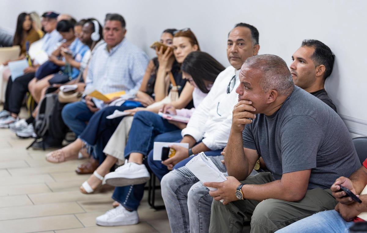 Mariano Macias, 43, far right, waits for his turn alongside others inside the Miami Central DMV office on Wednesday, April 16, 2025, in Miami.
